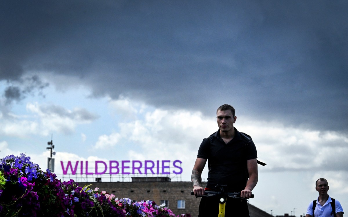 People walk past Russian e-commerce giant Wildberries' logo in downtown Moscow on July 27, 2026. Wildberries -- Russia's version of Amazon -- has been targeted by Kyiv's drones for a week, which have caused fires and business losses. Kyiv has in recent months intensified its strikes on Russian territory, disrupting the lives of ordinary Russians -- strikes it calls retribution for more than four years of bombardments against its territory. (Photo by Alexander NEMENOV / AFP)