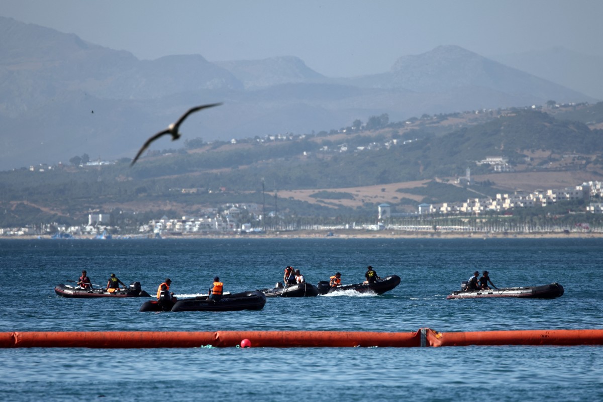 People aboard inflatable boats navigate on the Moroccan side of the new floating barrier deployed by Spain to reinforce security near the border post of the Spanish enclave of Ceuta on August 2, 2026.  (Photo by Henry Nicholls / AFP)