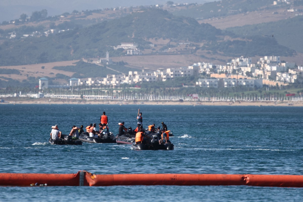 People aboard inflatable boats navigate on the Moroccan side of the new floating barrier deployed by Spain to reinforce security near the border post of the Spanish enclave of Ceuta on August 2, 2026. (Photo by Henry Nicholls / AFP)