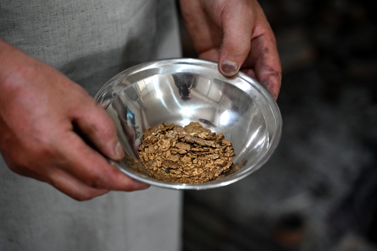 This photograph taken on August 5, 2026 shows an Afghan goldsmith holding gold at a workshop in Fayzabad, in Afghanistan's northeastern Badakhshan province. In Afghanistan's northeastern Badakhshan province, dozens of excavators operate day and night to extract gold from the mountains where villagers and their livestock once roamed. (Photo by OMER ABRAR / AFP)
