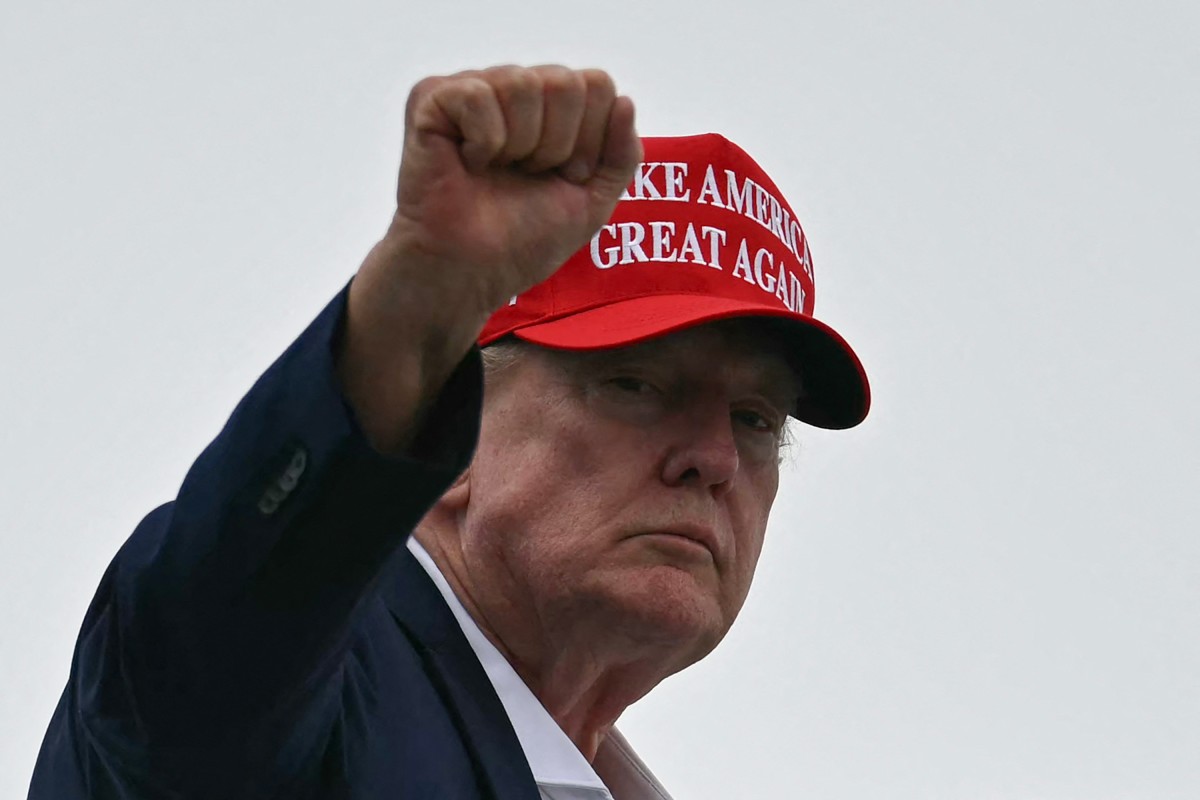 US President Donald Trump gestures as he boards Air Force One at Morristown Municipal Airport in Morristown, New Jersey, on August 16, 2026. President Trump is travelling back to Washington, DC, after spending the weekend at his golf club in New Jersey. (Photo by Kent NISHIMURA / AFP)