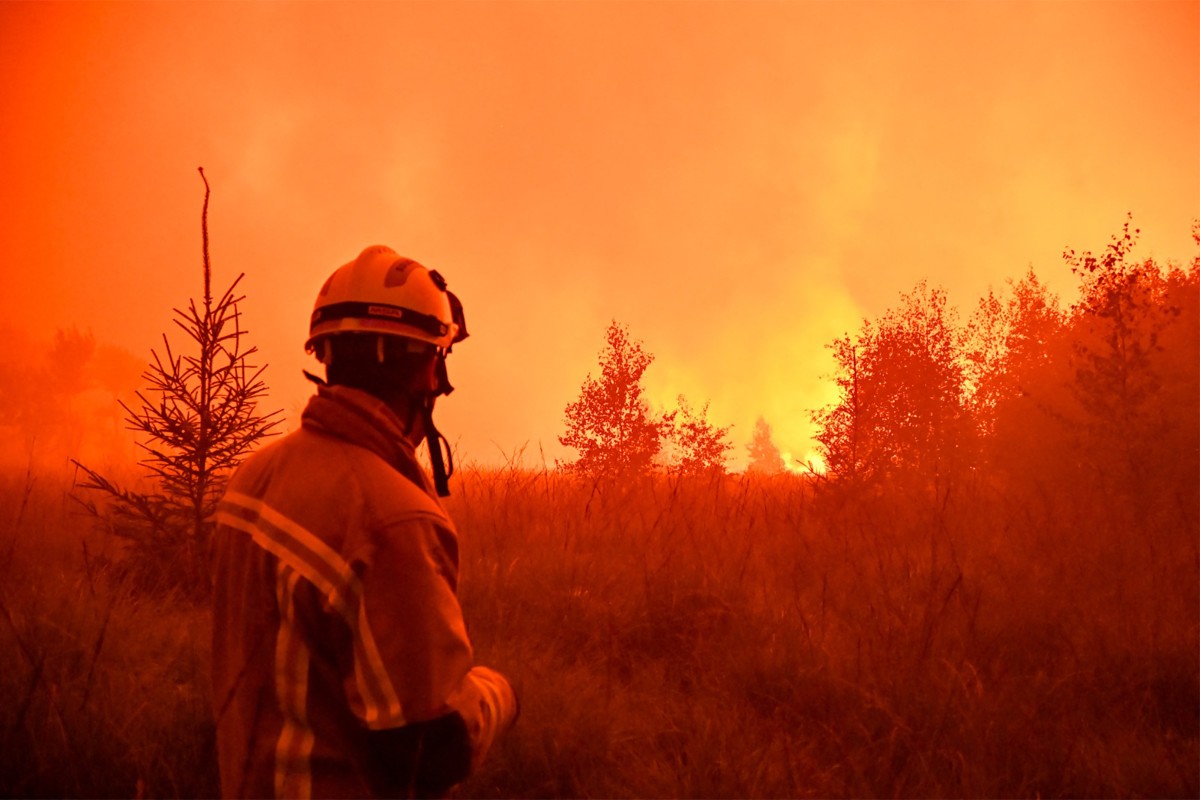 Rain started falling in Belgium on August 17, 2026 to help its fight against the country's biggest modern-day wildfire that has devastated some 3,000 hectares (7,500 acres) of the High Fens park on the border with Germa. Some 500 firefighters and troops are battling the blaze that has sent a huge cloud of black smoke across the region into neighbouring Germany and France. (Photo by Handout / VHP / AFP)  