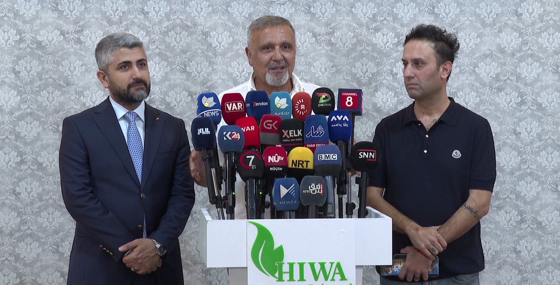 Renowned Kurdish singer Kamal Muhammad (center), alongside Dr. Yad Naqshbandi, Director of Hiwa Cancer Hospital (left), addresses a press conference in Sulaymaniyah to announce "A Hope for Hiwa," a two-day charity concert set for August 27 to raise funds for cancer patients and medical equipment at the hospital.