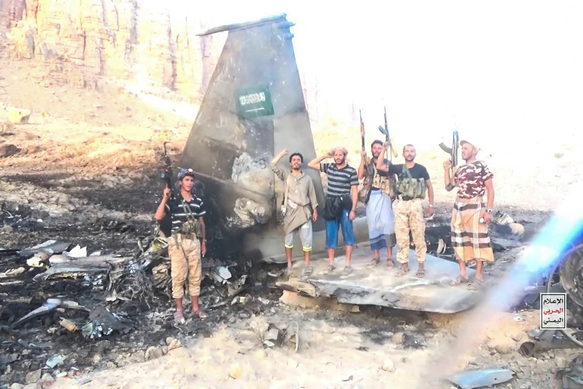 This handout picture released on September 16, 2026 by Ansarullah Media Centre shows fighters affiliated with Houthi authorities posing in the midst of what the Houthi military said is the wreckage of a Saudi F-15 fighter jet that was shot down in the central province of Marib.