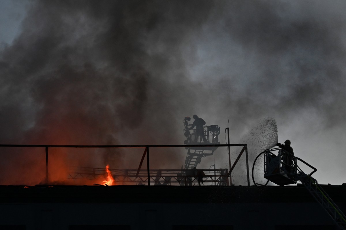 Firefighters put out a fire on the roof of a business centre burning following a drone attack in Kyiv on September 25, 2026, amid the Russian invasion of Ukraine. Russian strikes on Kyiv killed five people during the day on September 25, including a 14-year-old boy, local authorities said, as Ukraine's leader disclosed that Donald Trump had approved licences for Patriot air defence systems. (Photo by Sergei SUPINSKY / AFP)
