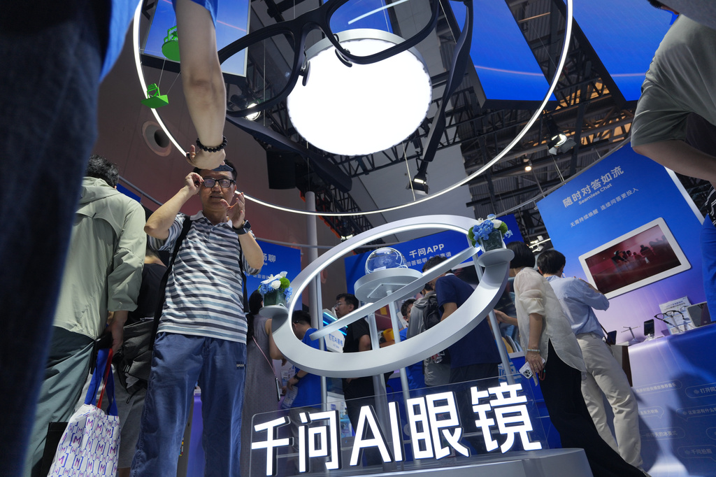 A visitor tries out Alibaba's Qwen AI glasses during the World AI Conference in Shanghai, China on July 17, 2026. (AP Photo/Ng Han Guan)