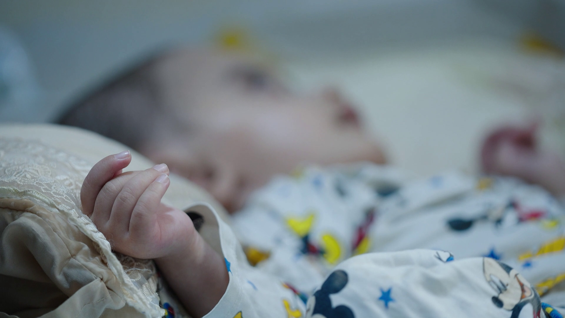 An abandoned infant lies in a hospital crib in the Hawija district of Kirkuk province. A recent investigation by Radar8 revealed a sharp rise in child abandonment across the district, driven primarily by severe economic hardship, poverty, and intense social stigma surrounding out-of-wedlock births and children with severe health conditions. (Photo: Channel8 / Radar8)