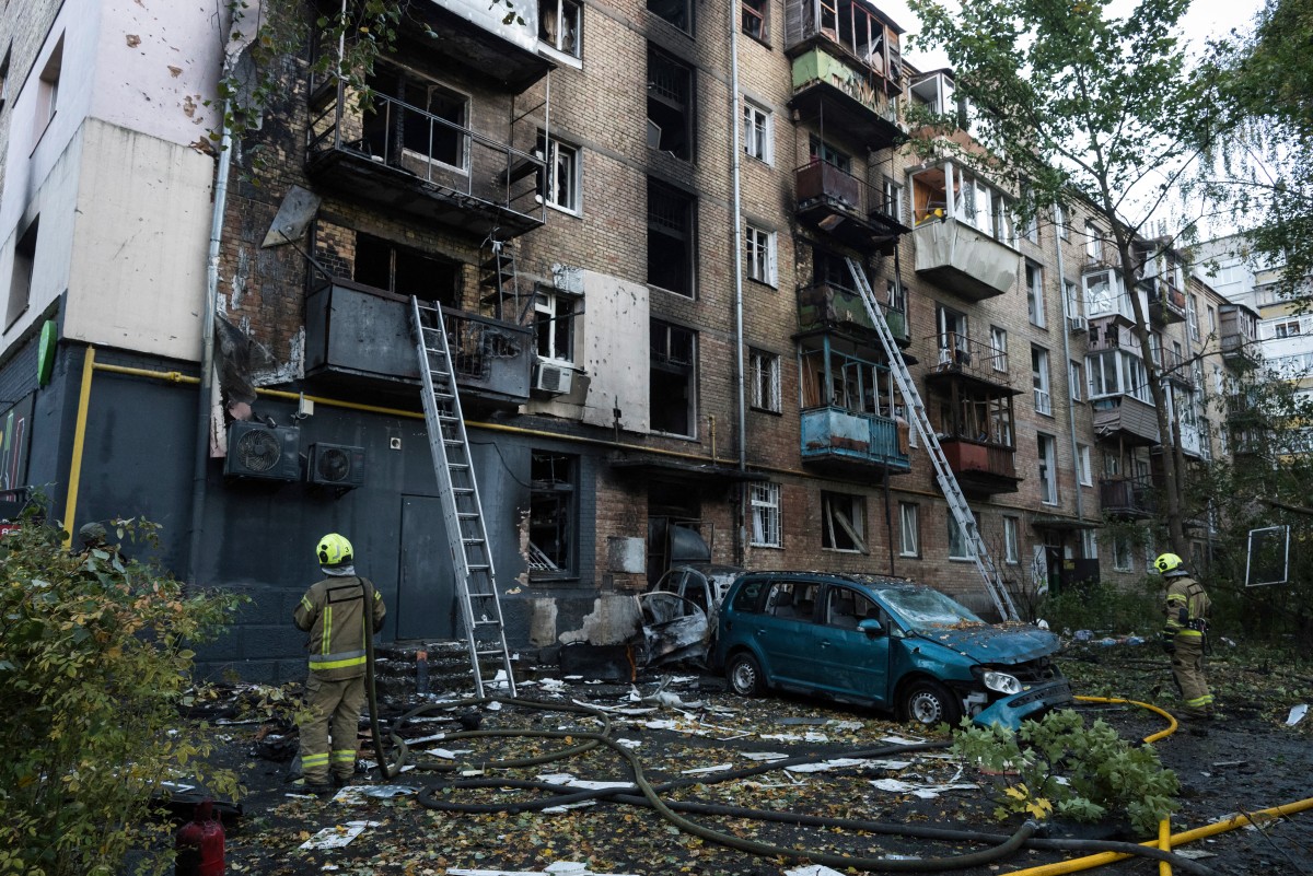 Rescuers work outside a damaged five-story residential building following a Russian drone attack in Kyiv on October 7, 2026, amid the Russian invasion of Ukraine. (Photo by Vladyslav Musiienko / AFP)