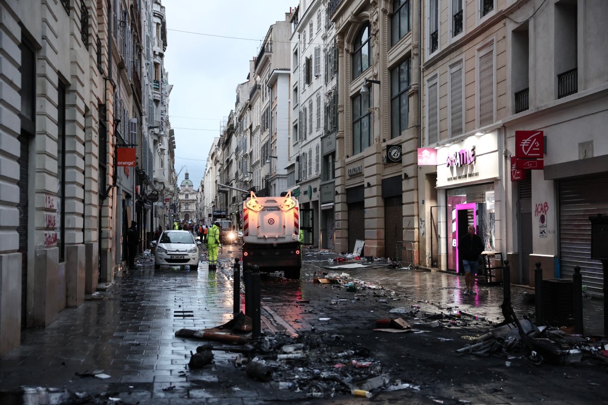 Municipal cleaning workers clean a street a day after nationwide protests against the "high cost of living", in Marseille on October 18, 2026.  (Photo by Thibaud MORITZ / AFP)