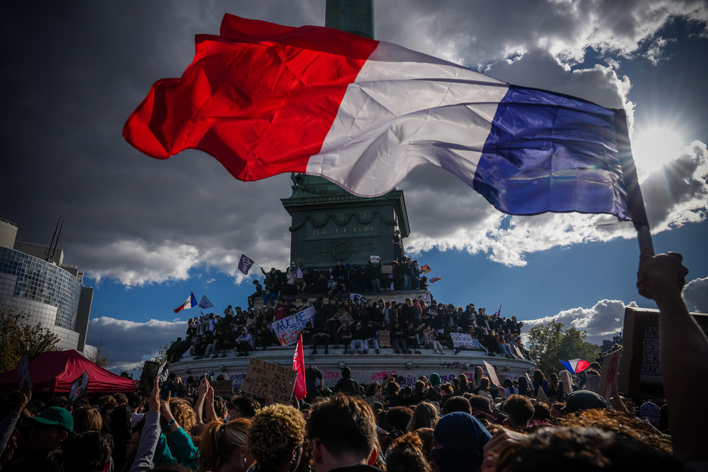 A person holds a French national flag during a protest against under-resourced schools in Paris, Thursday, Oct. 8, 2026. (AP Photo/Aurelien Morissard)
