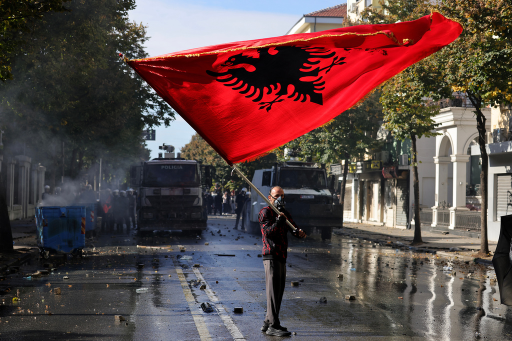 A protester waves an Albanian flag during an anti-government demonstration outside the Education Ministry, in Tirana, Albania, Saturday, Oct. 17, 2026. (AP Photo/Hameraldi Agolli)