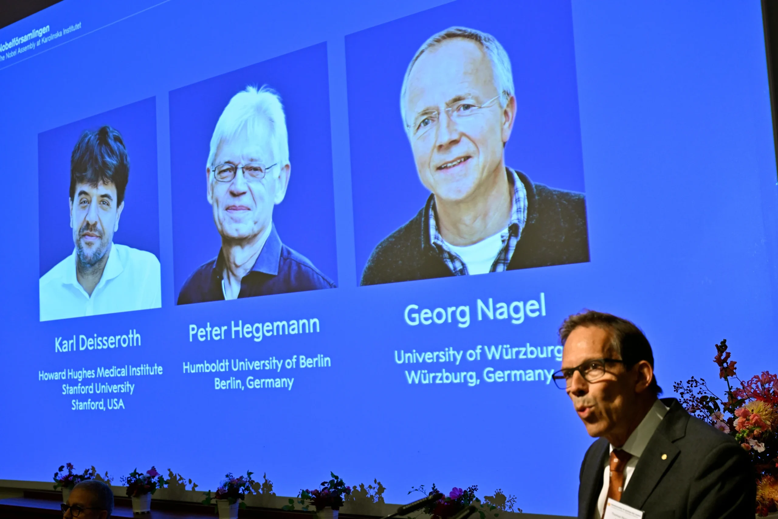 Karl Deisseroth, Peter Hegemann and Georg Nagel are shown on the screen as they are awarded the 2026 Nobel Prize in Physiology or Medicine, as announced during a press conference at the Nobel Forum at Karolinska Institutet in Stockholm, Sweden, Oct. 5, 2026.
