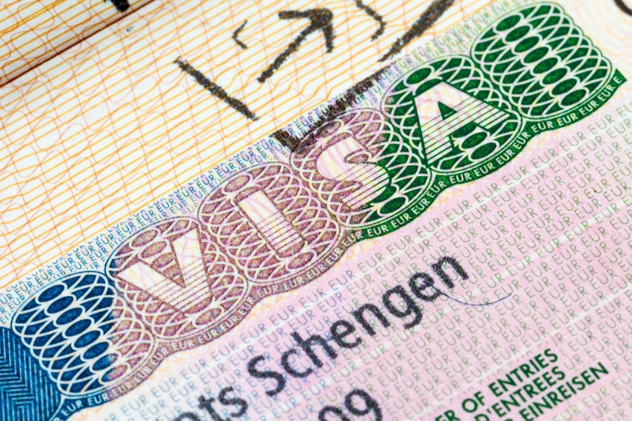 An official Schengen visa sticker affixed to a passport page 
