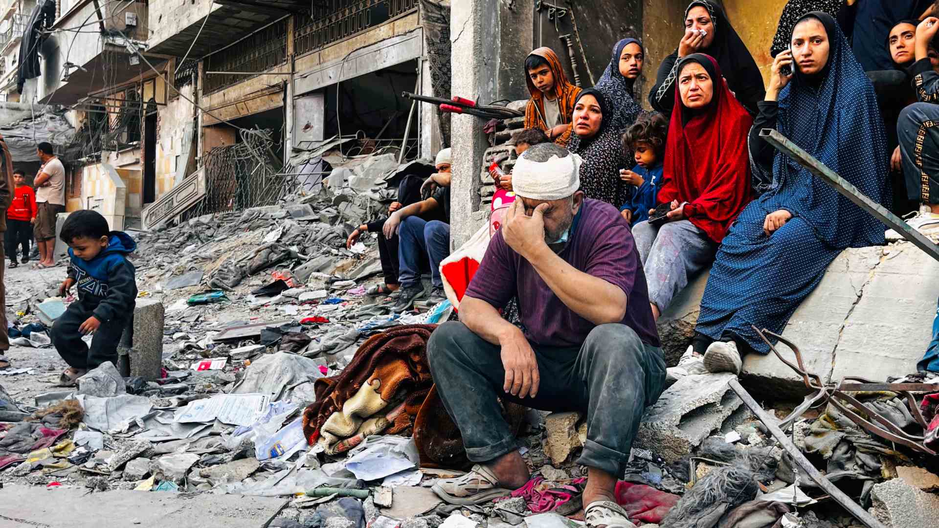 ژمارەیەك هاوڵاتیی كەرتی غەززە لەناو داروپەردووی بۆردوومانەكەدا دانیشتوون. فۆتۆ: AFP