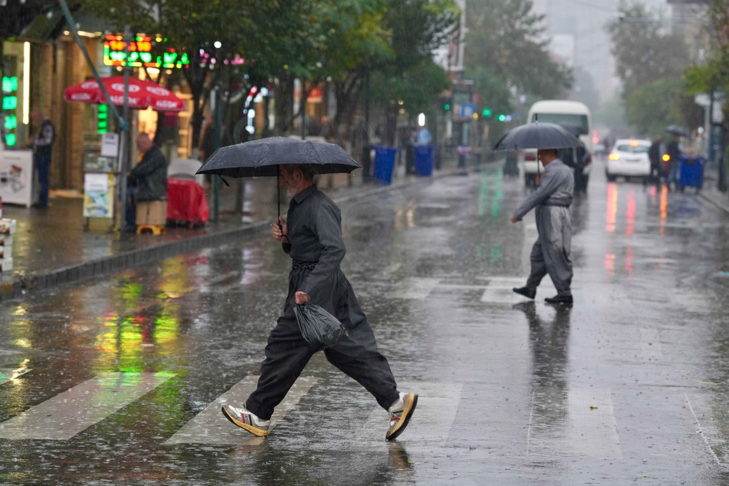 دیمەنێکی چەند هاونیشتمانییەکی شاری سلێمانی لە کاتی بارانباریندا لەسەر یەکێک لە شەقامەکاندا. فۆتۆ: حەمەسوور - کەناڵ8
