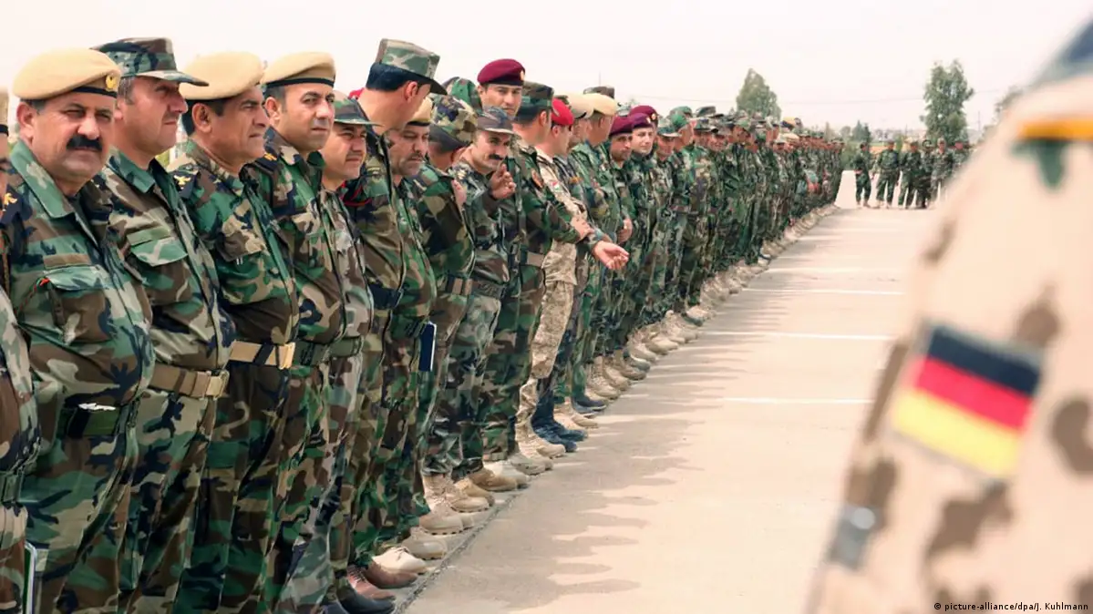 ڕاهێنەرێکی هێزەکانی ئەڵمانیا لە کاتی ڕاهێنان بە هێزەکانی پێشمەرگە لە هەرێمی کوردستان