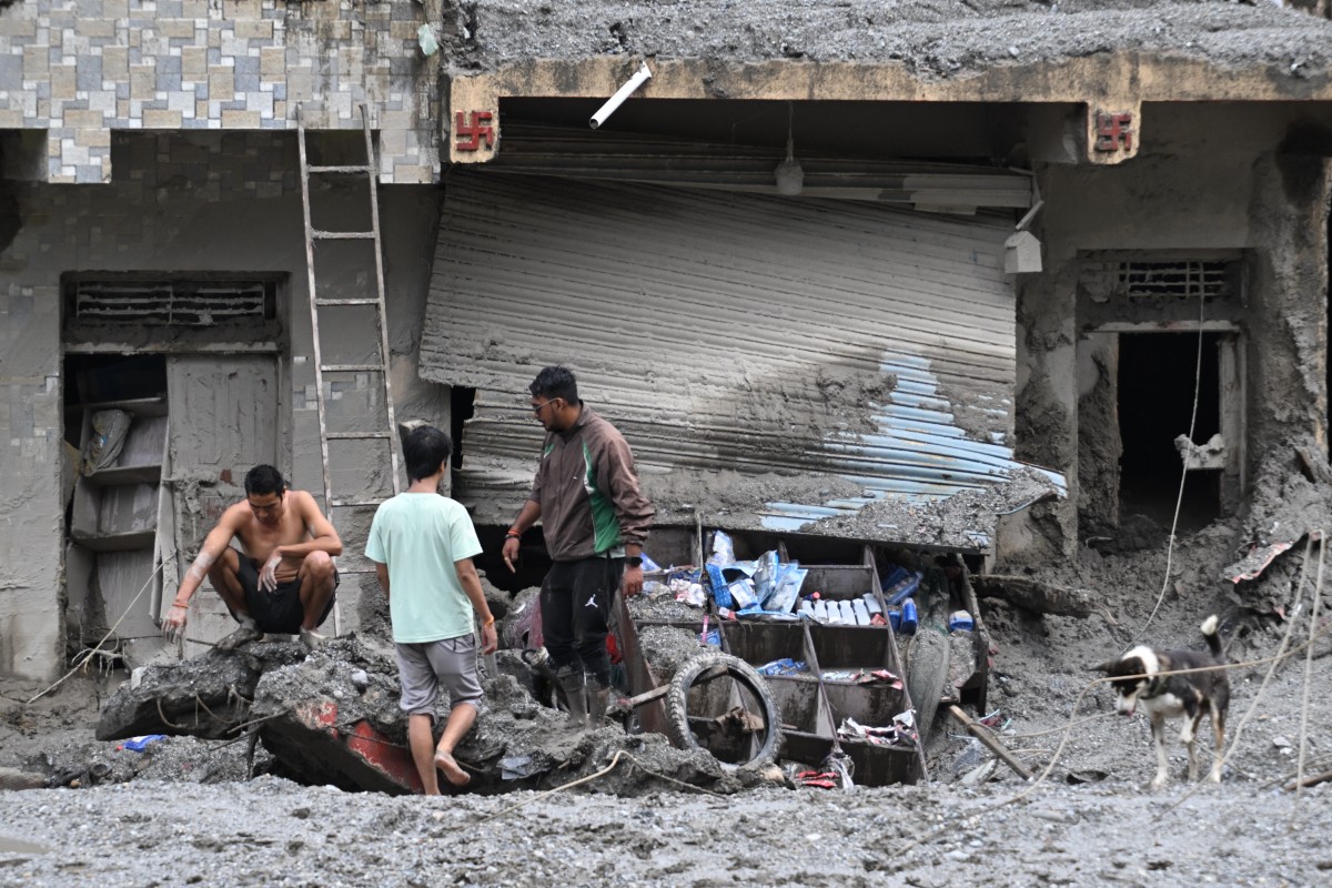 چەند هاوڵاتییەکی نیپاڵ بە دیار خانووەکانیانەو ە بێدەسەڵات دۆش داماون، فۆتۆ: AFP 